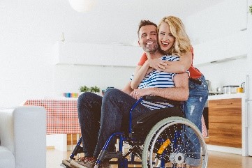 Image of man in a wheelchair and woman smiling and hugging